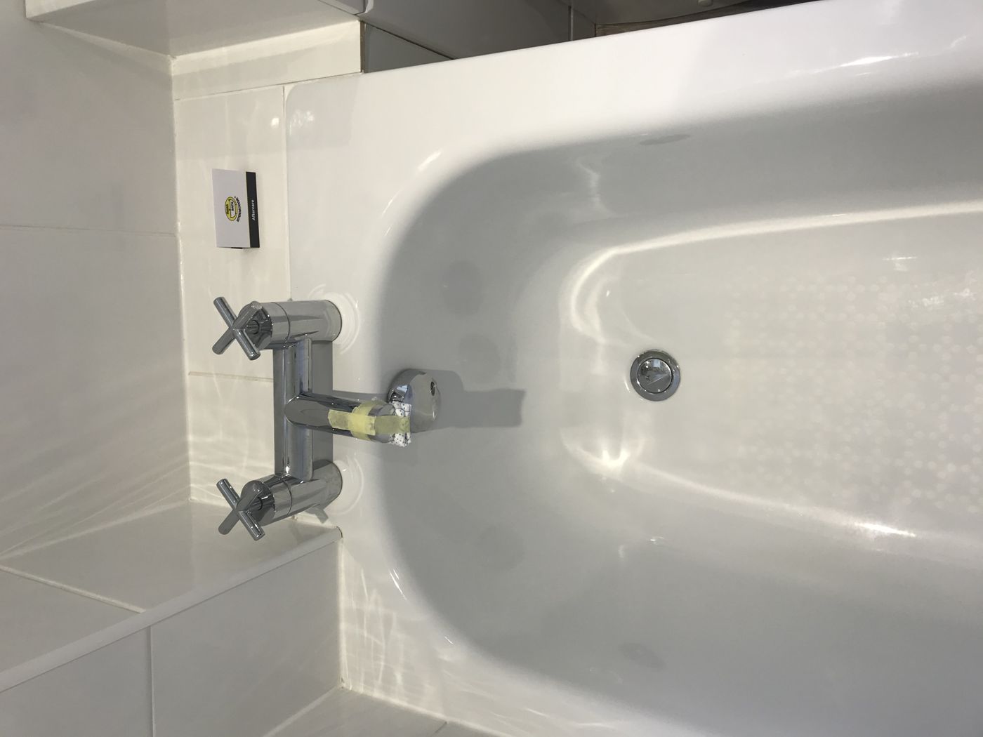 Close up of a bath's glossy surface around the taps after resurfacing